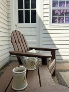 A brown chair and table outside on the patio.