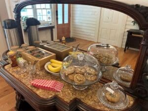 Treats such as cookies and bananas along with tea set out on a wooden server.