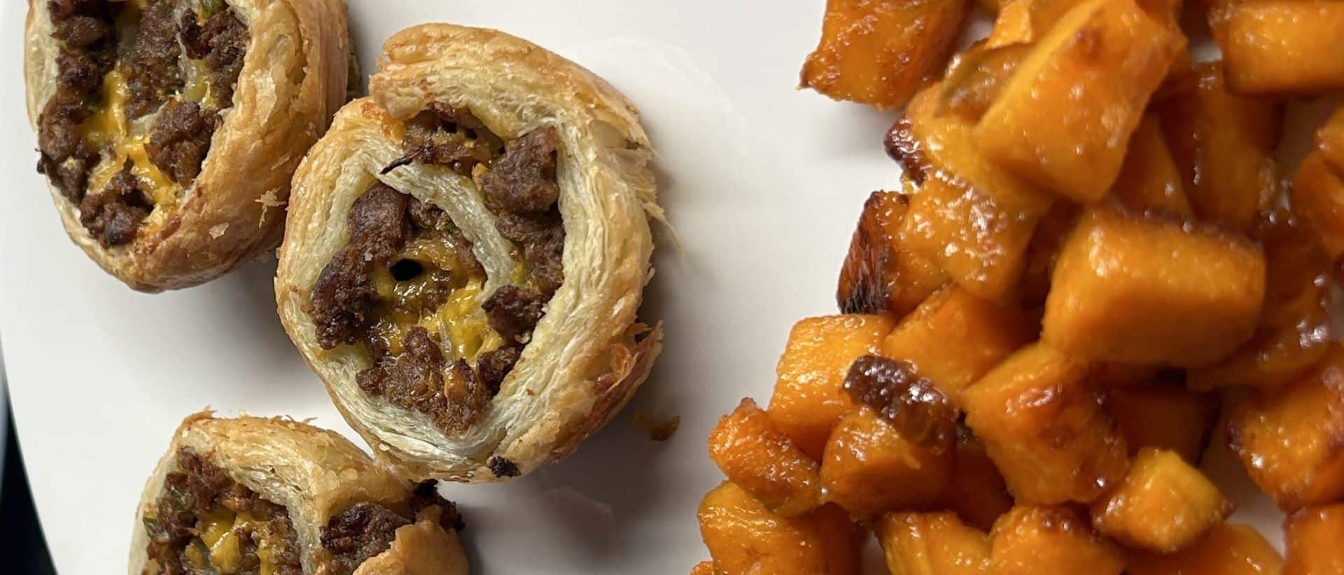 Breakfast foods of sweet potatoes and sausage rolled in puff pastry