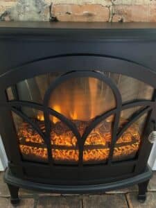 An orange glow of fire in the black fireplace insert.