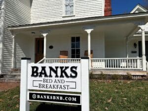 White house with Banks Bed and Breakfast sign in front of it.
