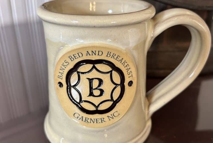 Tan mug with dark brown logo.