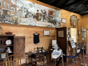 Mural on brown wooden wall with antique items on display. 