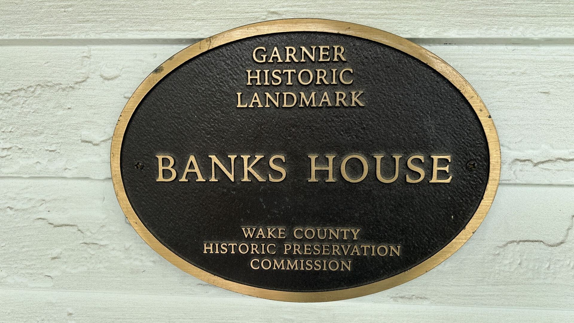 Bronze plaque on white house.