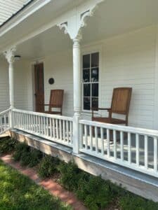 Rocking chairs on porch of white house.