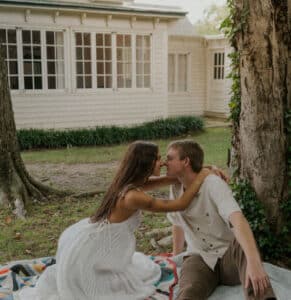Woman and man sitting on cloth and hugging. 