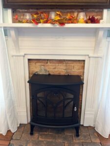 Brick fireplace with metal electric fireplace insert.