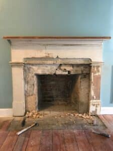 Fireplace in blue room with broken lining