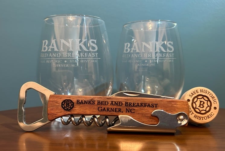 Two wine glasses with etched logo and wood bottle opener with engraving
